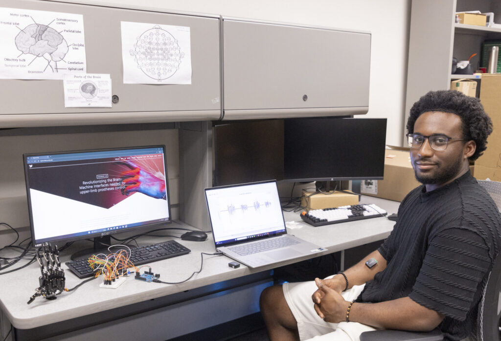 Caly Ferguson in the lab where he develops a mechanical hand driven by machine learning.